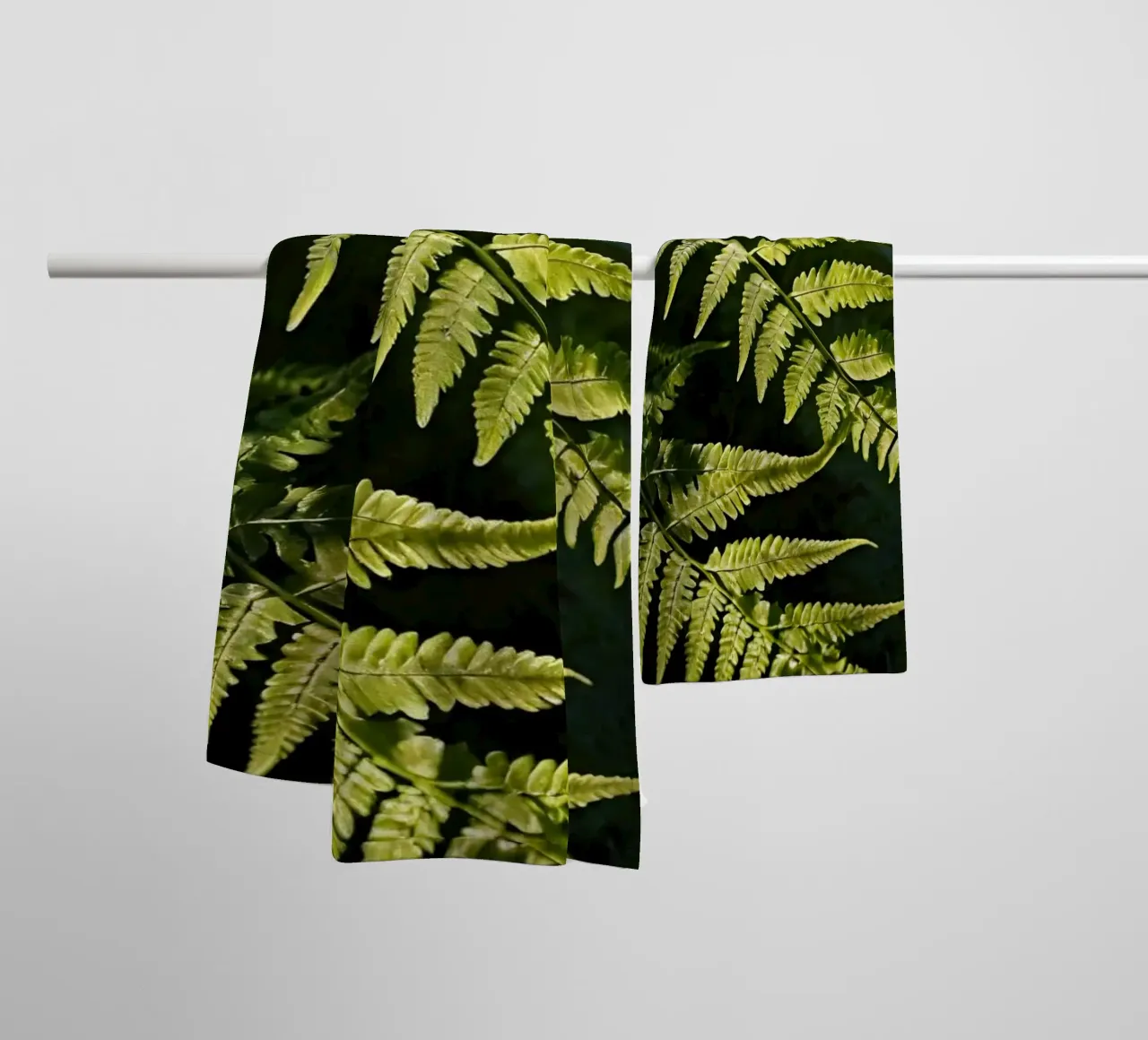 Sunlight filters through lush green ferns in a tranquil fore towel by DesignDoodle