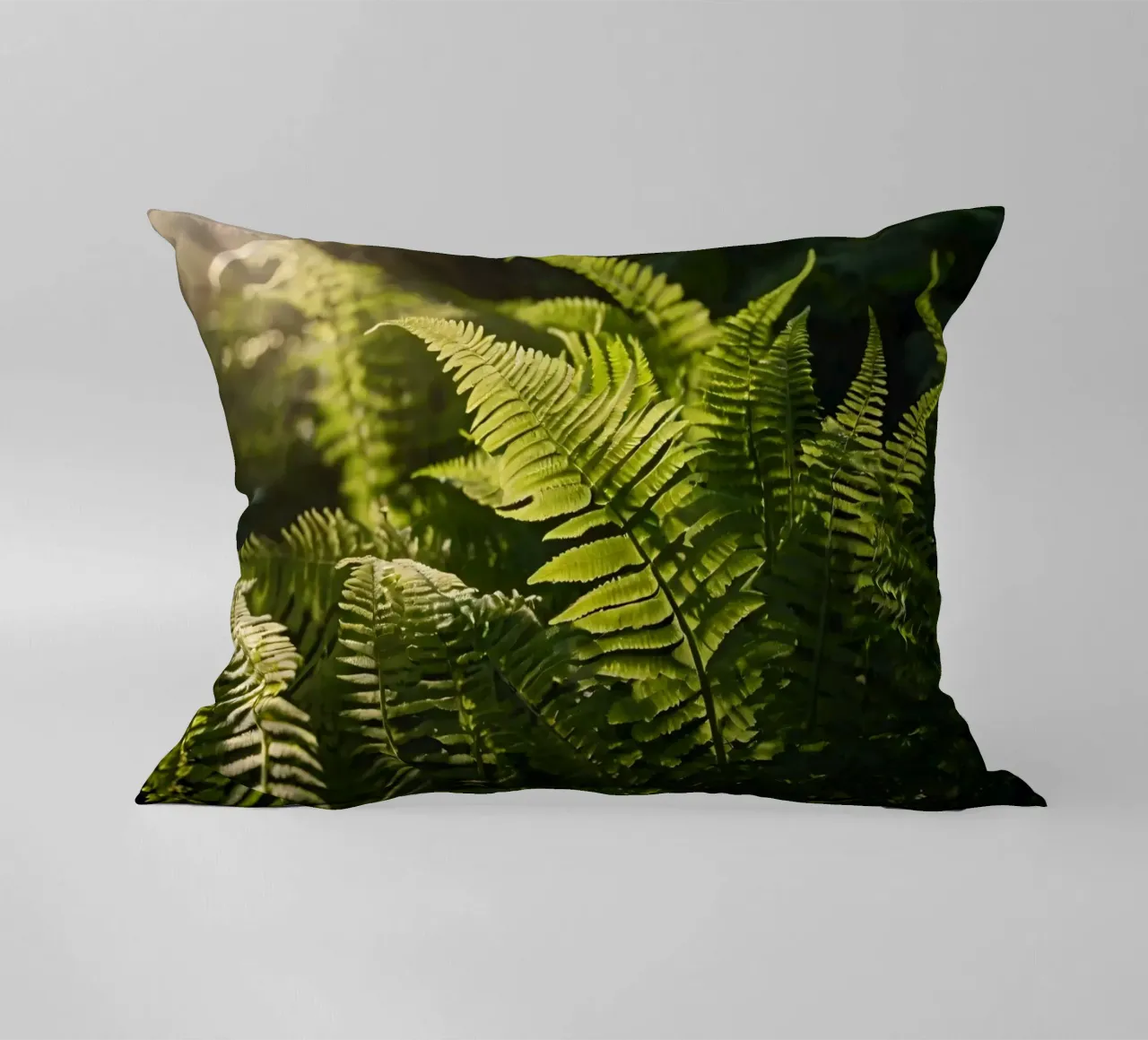 Felci verdi e rigogliose illuminate dalla luce del sole in una fitta foresta cuscino da DesignDoodle