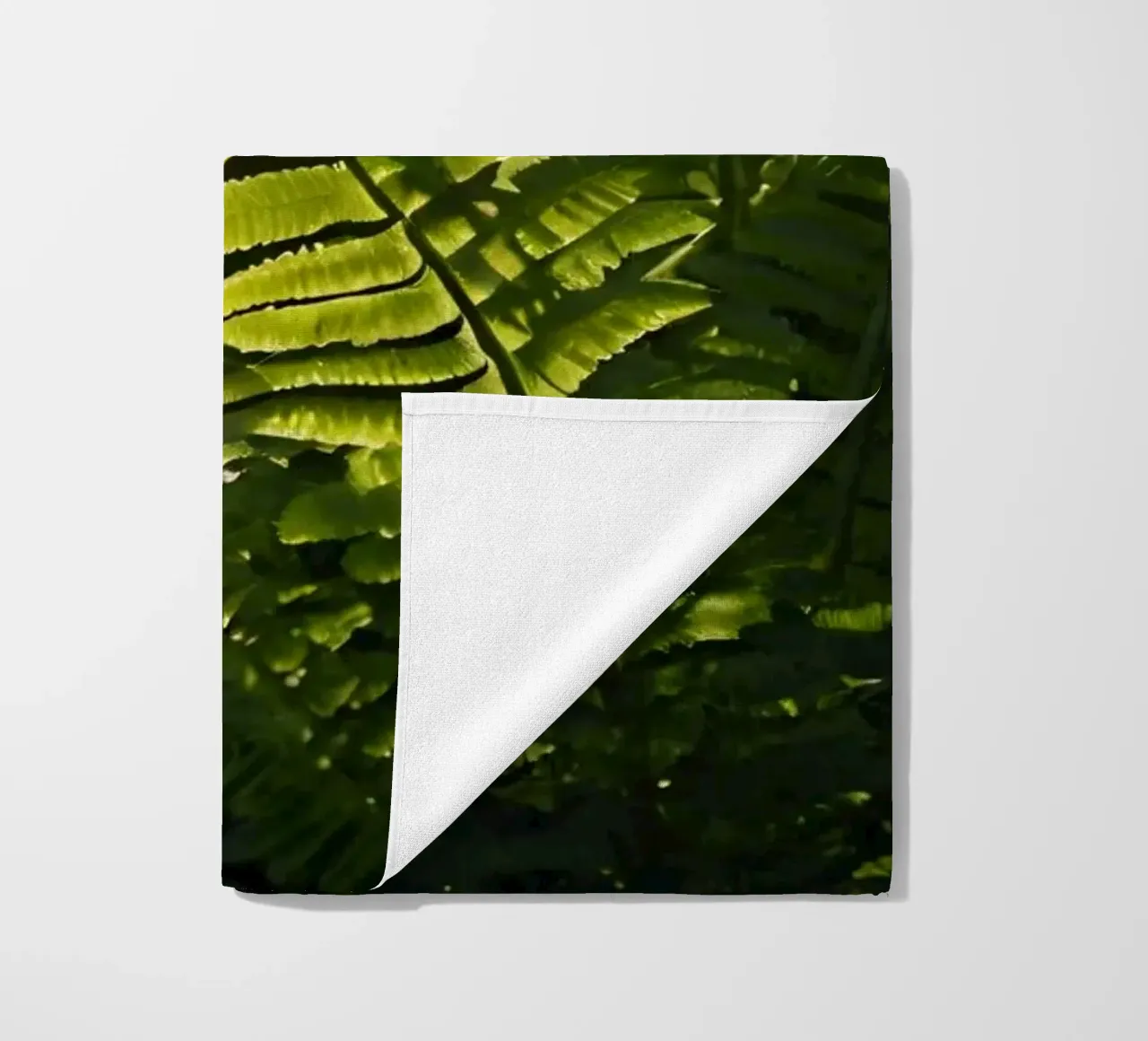 Exuberantes helechos verdes iluminados por la luz del sol en un denso bosque toalla de playa de DesignDoodle