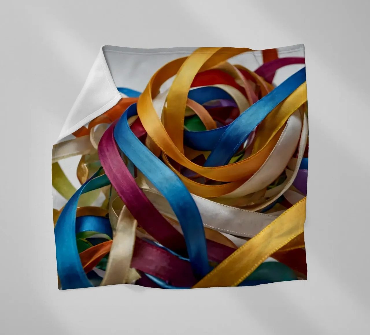 Nastri colorati aggrovigliati su una superficie bianca coperta in pile da DesignDoodle
