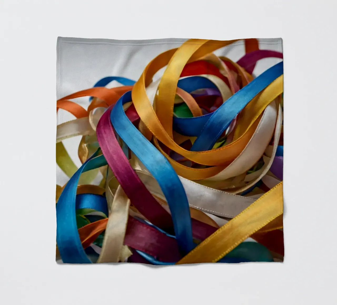 Nastri colorati aggrovigliati su una superficie bianca coperta in pile da DesignDoodle