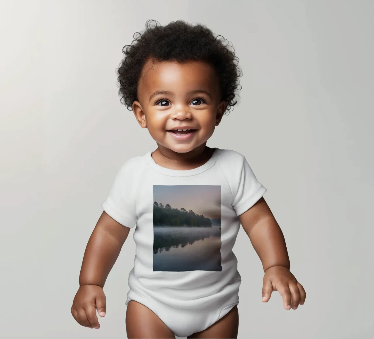 mist rises over a tranquil lake surrounded by lush trees short-sleeve baby romper by DesignDoodle