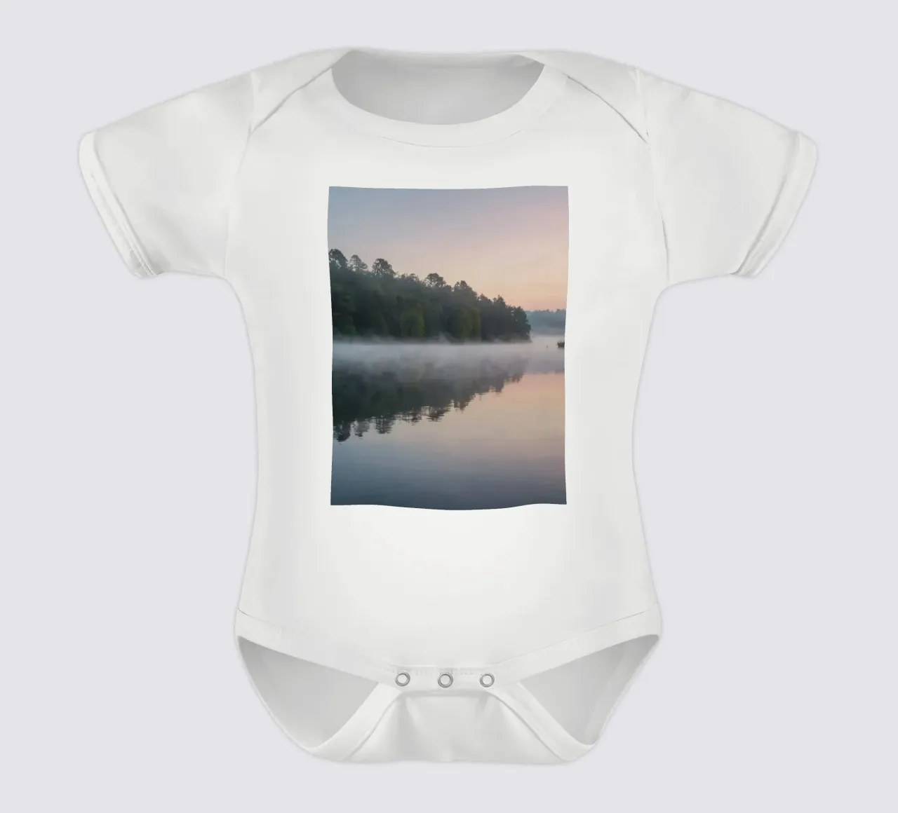 mist rises over a tranquil lake surrounded by lush trees short-sleeve baby romper by DesignDoodle
