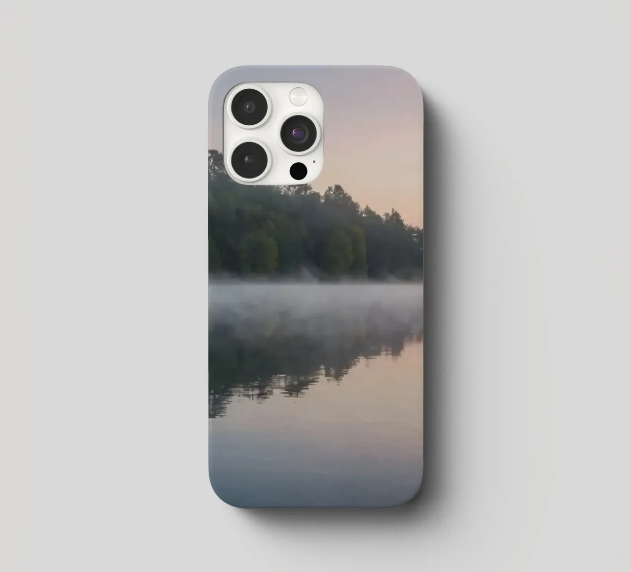 mist rises over a tranquil lake surrounded by lush trees iphone case by DesignDoodle