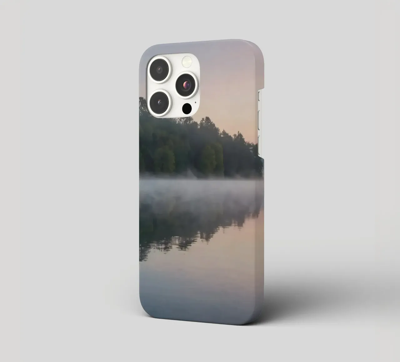 mist rises over a tranquil lake surrounded by lush trees iphone case by DesignDoodle