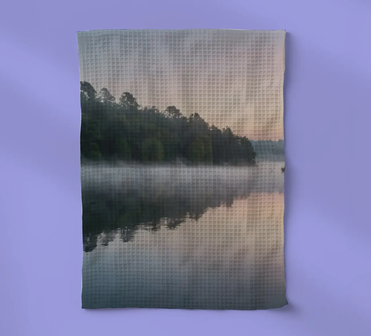 mist rises over a tranquil lake surrounded by lush trees tea towel by DesignDoodle