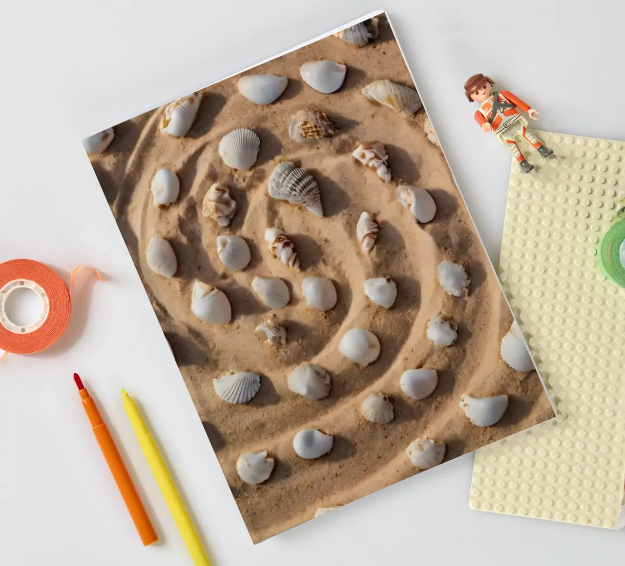 Spiral arrangement of seashells on sandy beach notebook by DesignDoodle