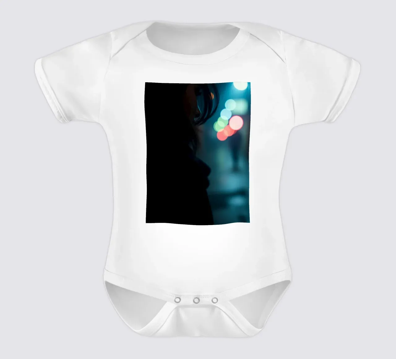 Eine Frau steht in einer schwach beleuchteten Straße und blickt in die Ferne. Kurzarm Babybody von DesignDoodle