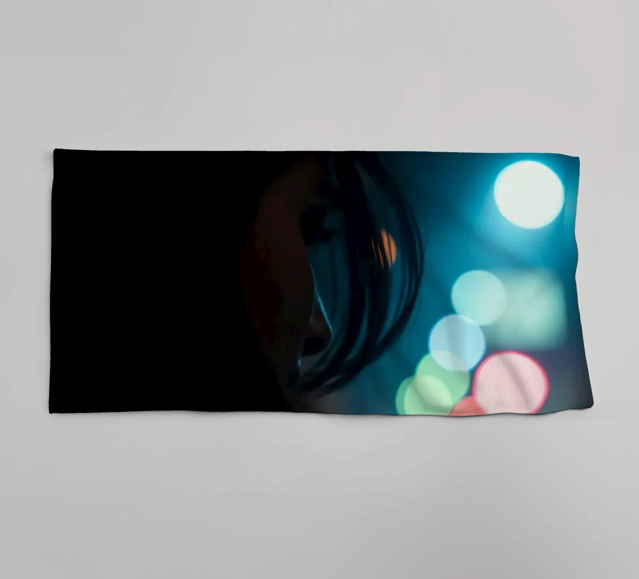 Una donna si trova in una strada scarsamente illuminata, con lo sguardo rivolto in lontananza asciugamano da bagno da DesignDoodle