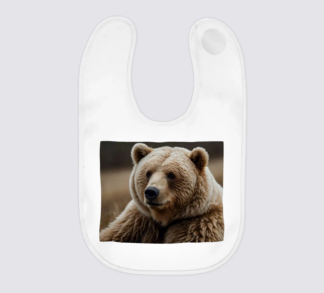 Vue rapprochée d'un ours brun se reposant dans un champ herbeux. bavoir de DesignDoodle