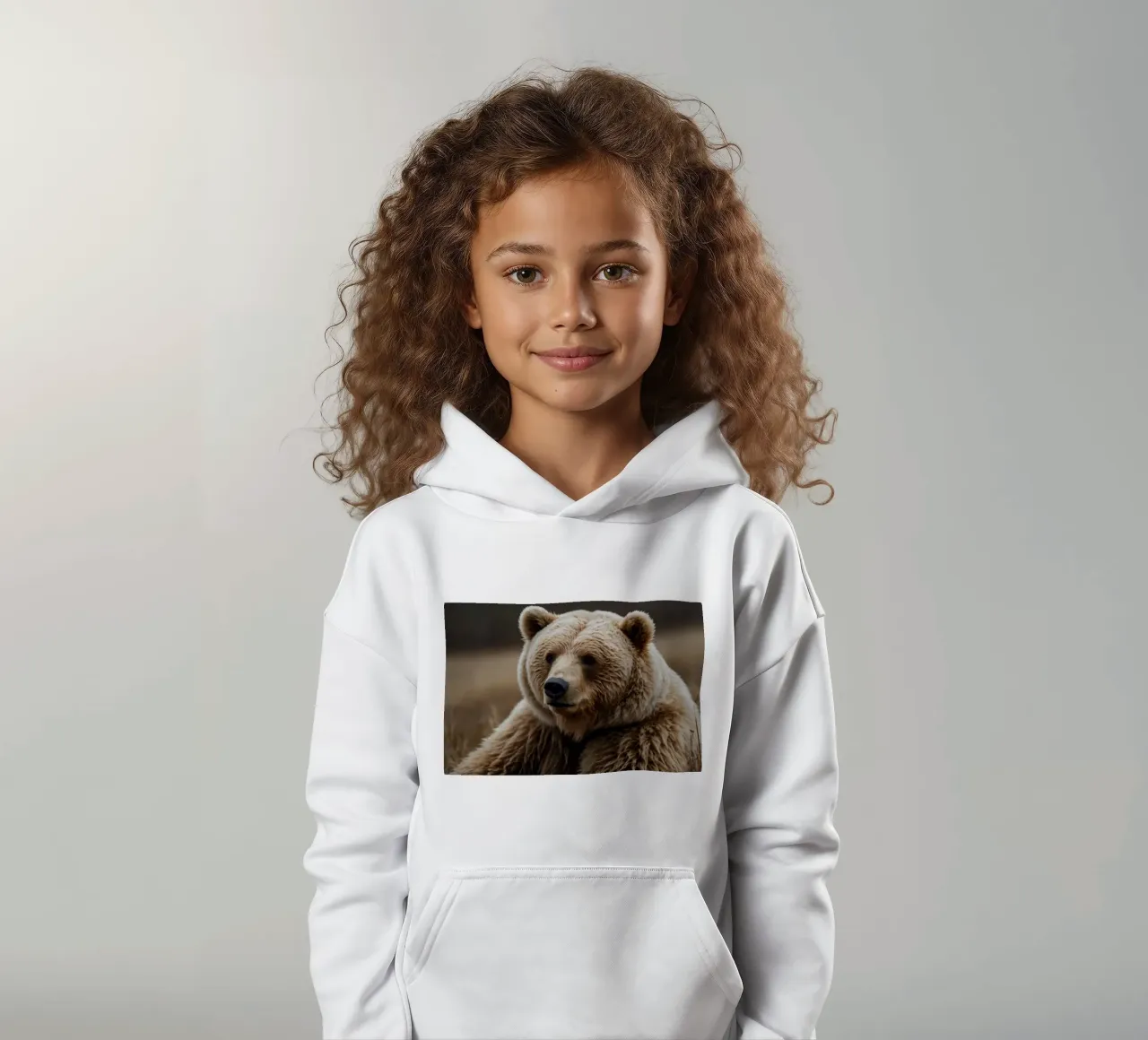Vue rapprochée d'un ours brun se reposant dans un champ herbeux. sweat à capuche enfant de DesignDoodle