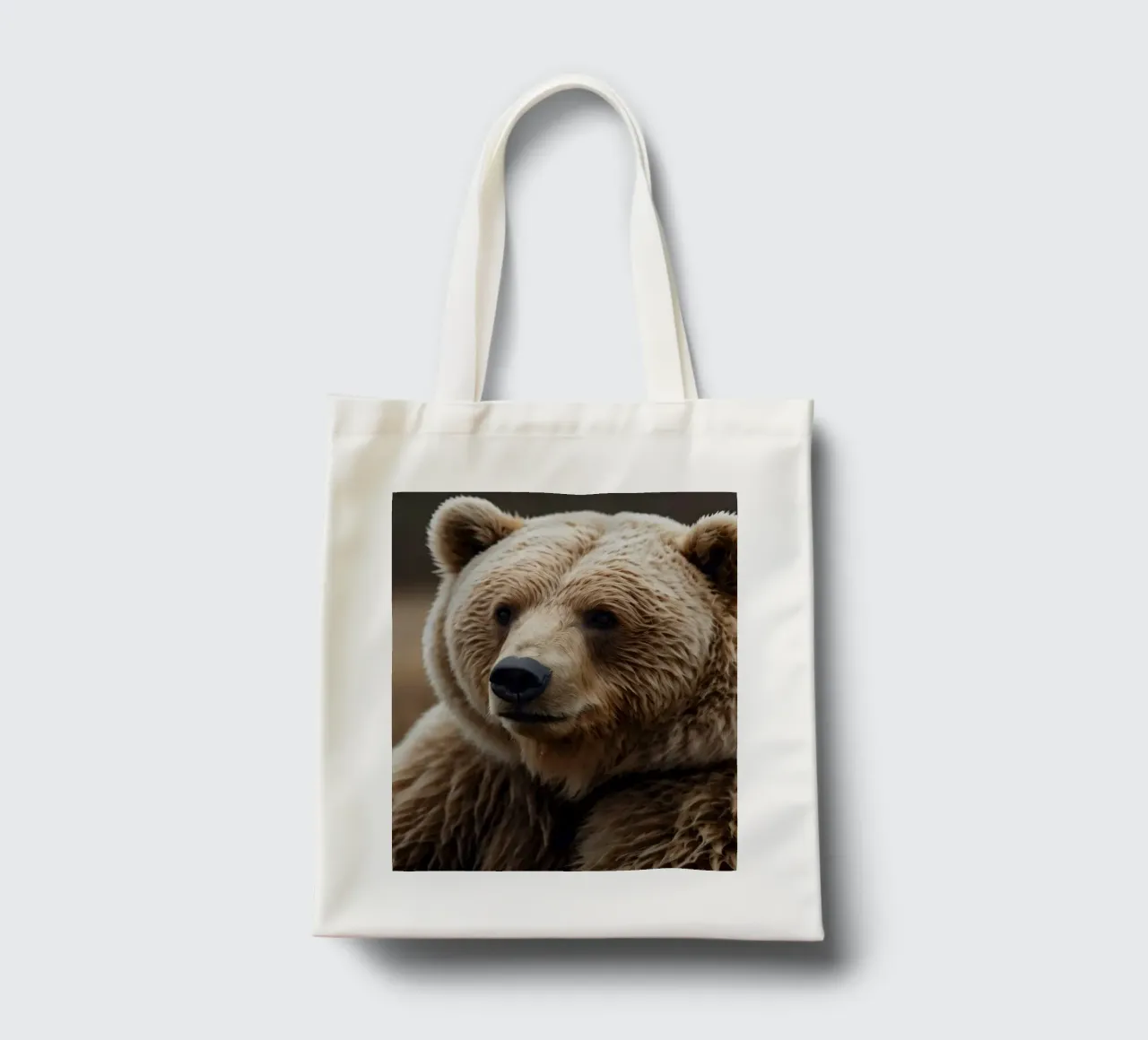 Vue rapprochée d'un ours brun se reposant dans un champ herbeux. tote bag de DesignDoodle