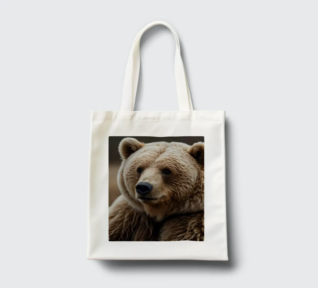 Vue rapprochée d'un ours brun se reposant dans un champ herbeux. tote bag de DesignDoodle