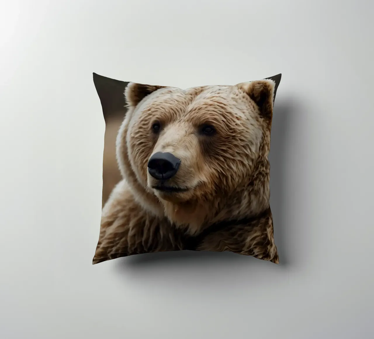 Vue rapprochée d'un ours brun se reposant dans un champ herbeux. coussin de DesignDoodle