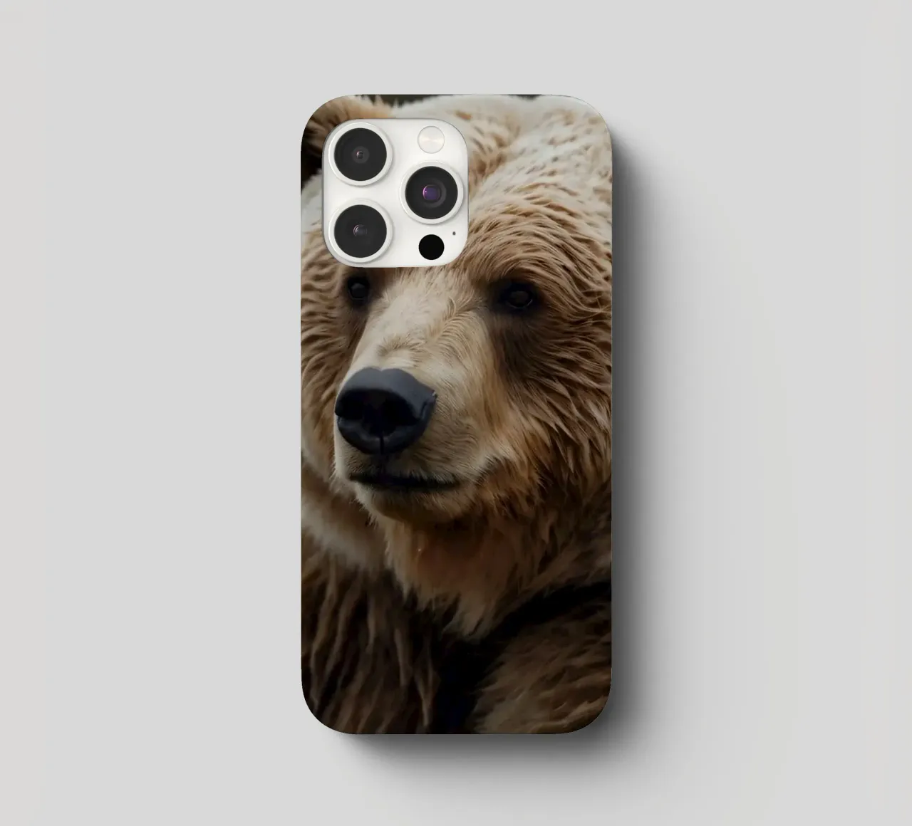 Vue rapprochée d'un ours brun se reposant dans un champ herbeux. coque iphone de DesignDoodle
