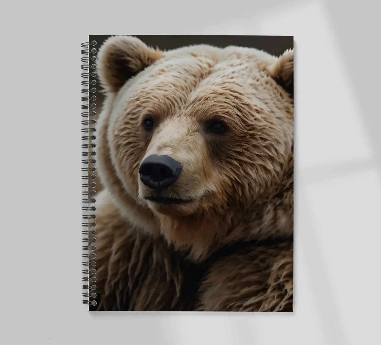 Vue rapprochée d'un ours brun se reposant dans un champ herbeux. carnet à spirale de DesignDoodle
