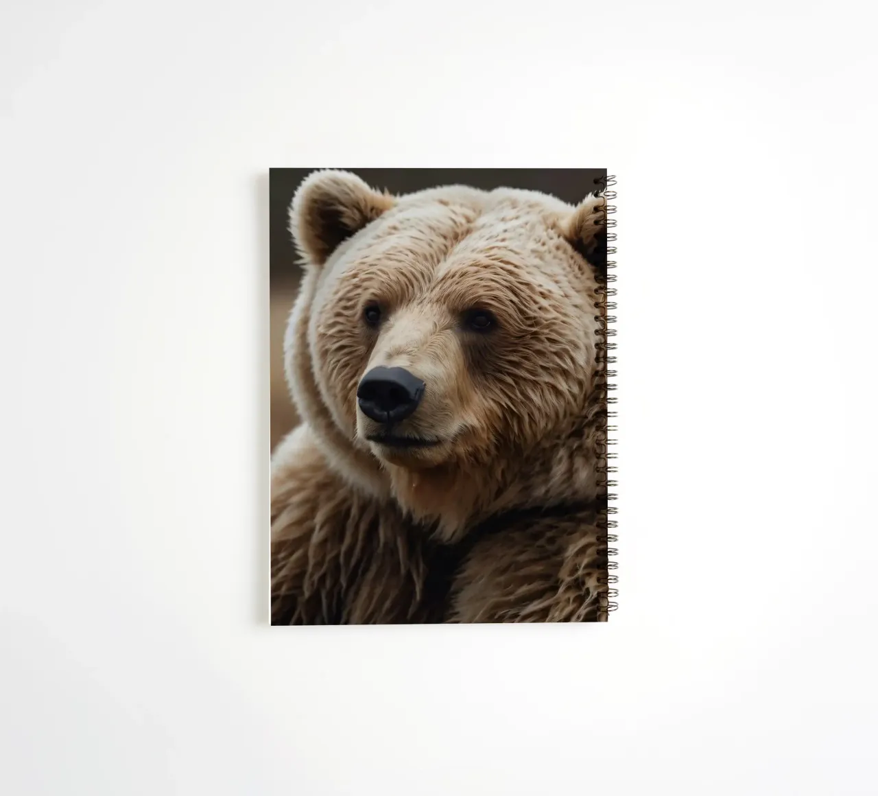 Vue rapprochée d'un ours brun se reposant dans un champ herbeux. carnet à spirale de DesignDoodle
