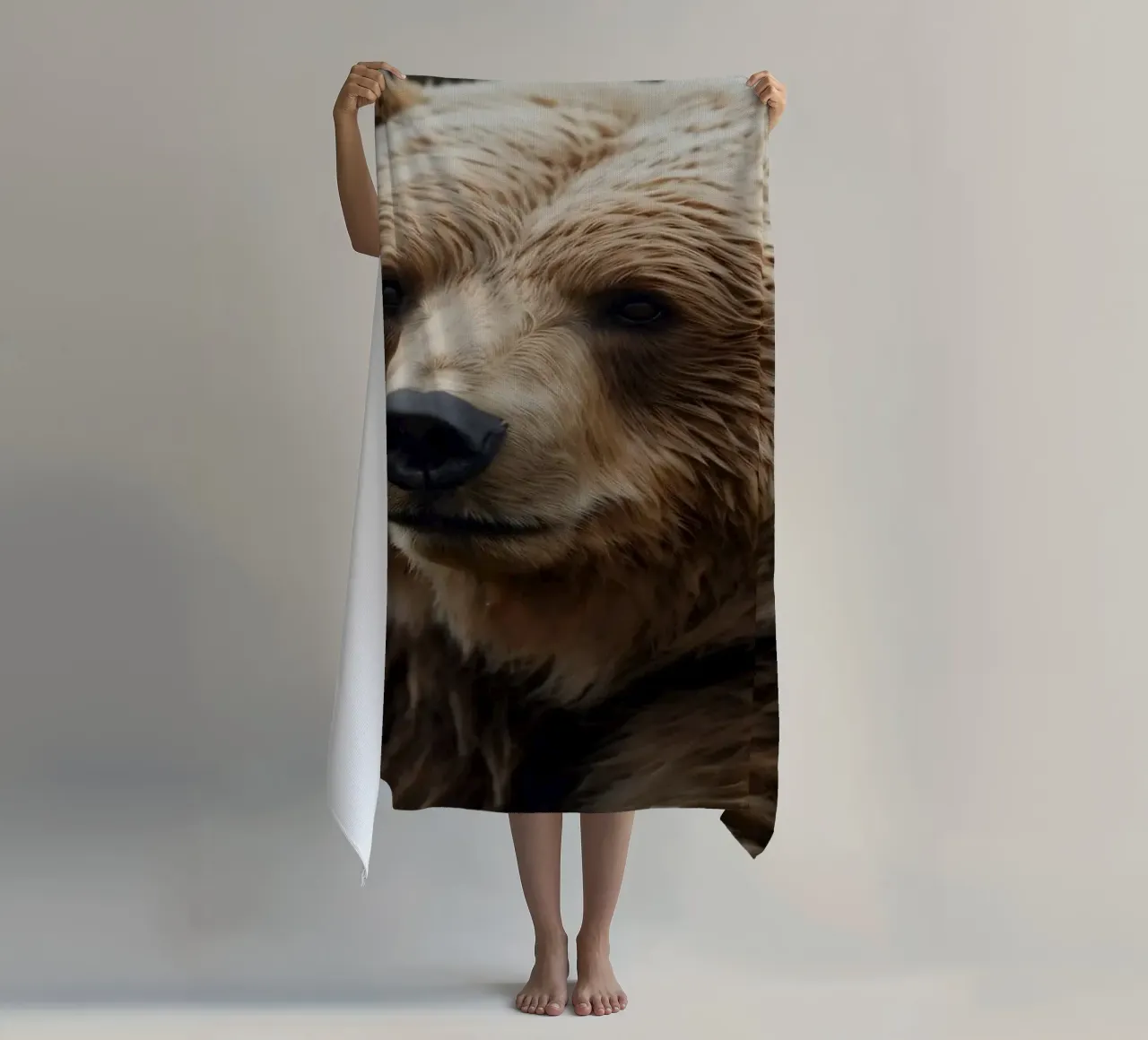 Vue rapprochée d'un ours brun se reposant dans un champ herbeux. serviette de plage de DesignDoodle