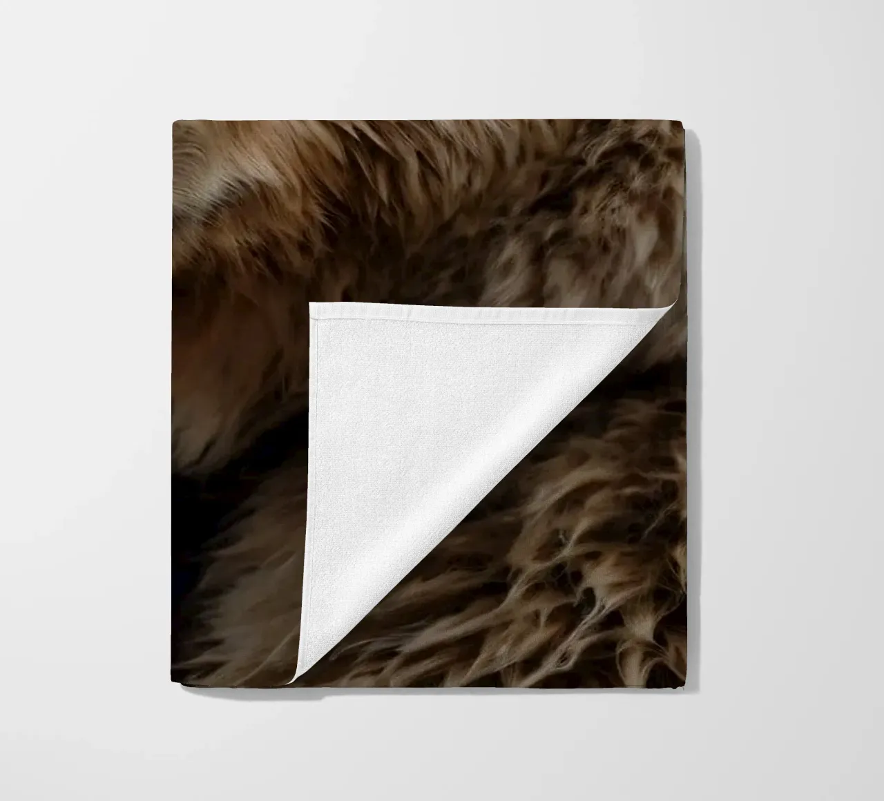 Vue rapprochée d'un ours brun se reposant dans un champ herbeux. serviette de plage de DesignDoodle