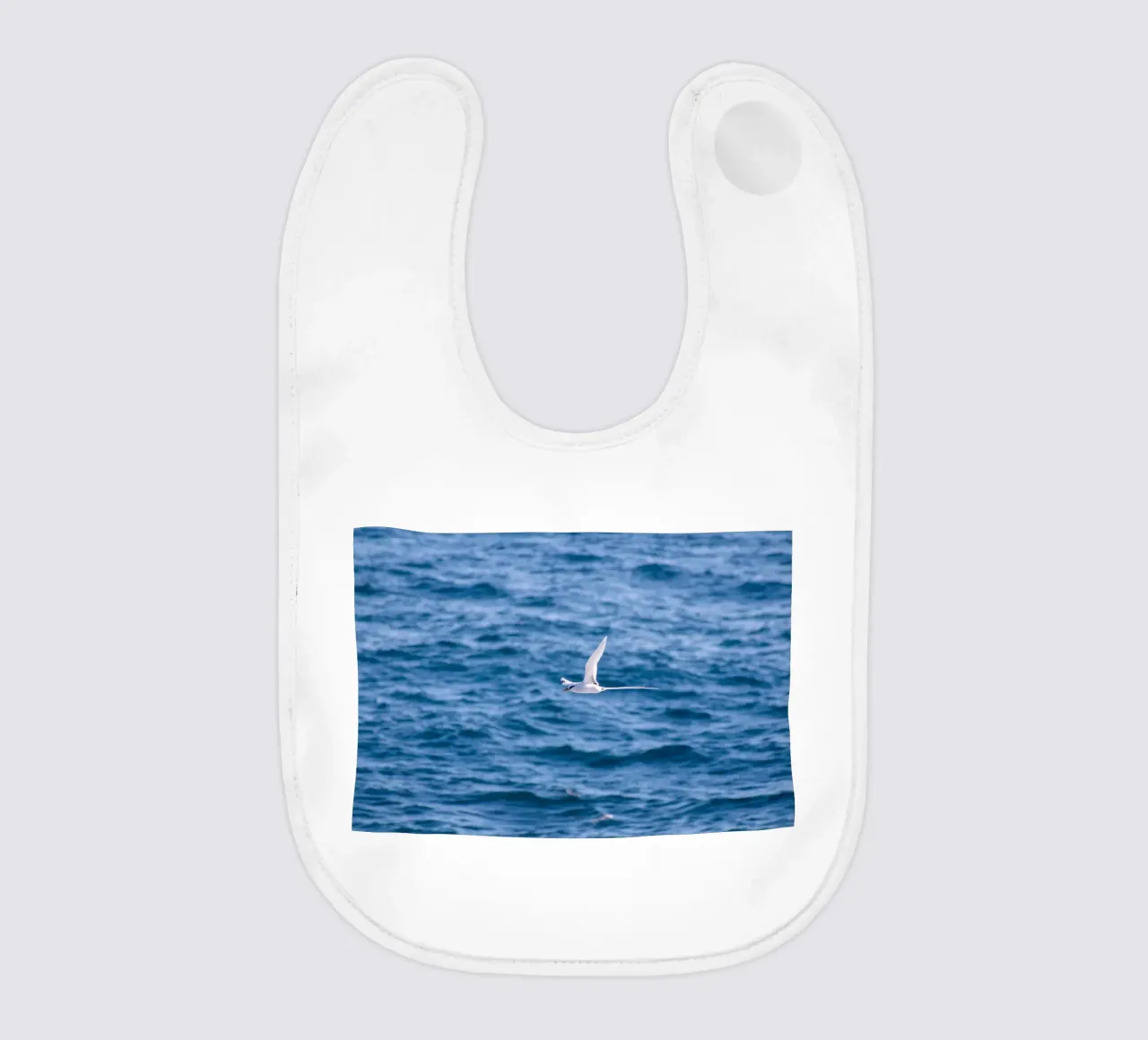 Uccello bianco in volo sul mare 1 bavaglino da Léa Lefebvre Photography