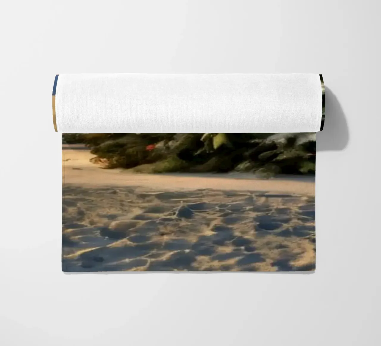 Snow-covered landscape featuring a decorated Christmas tree beach towel by DesignDoodle