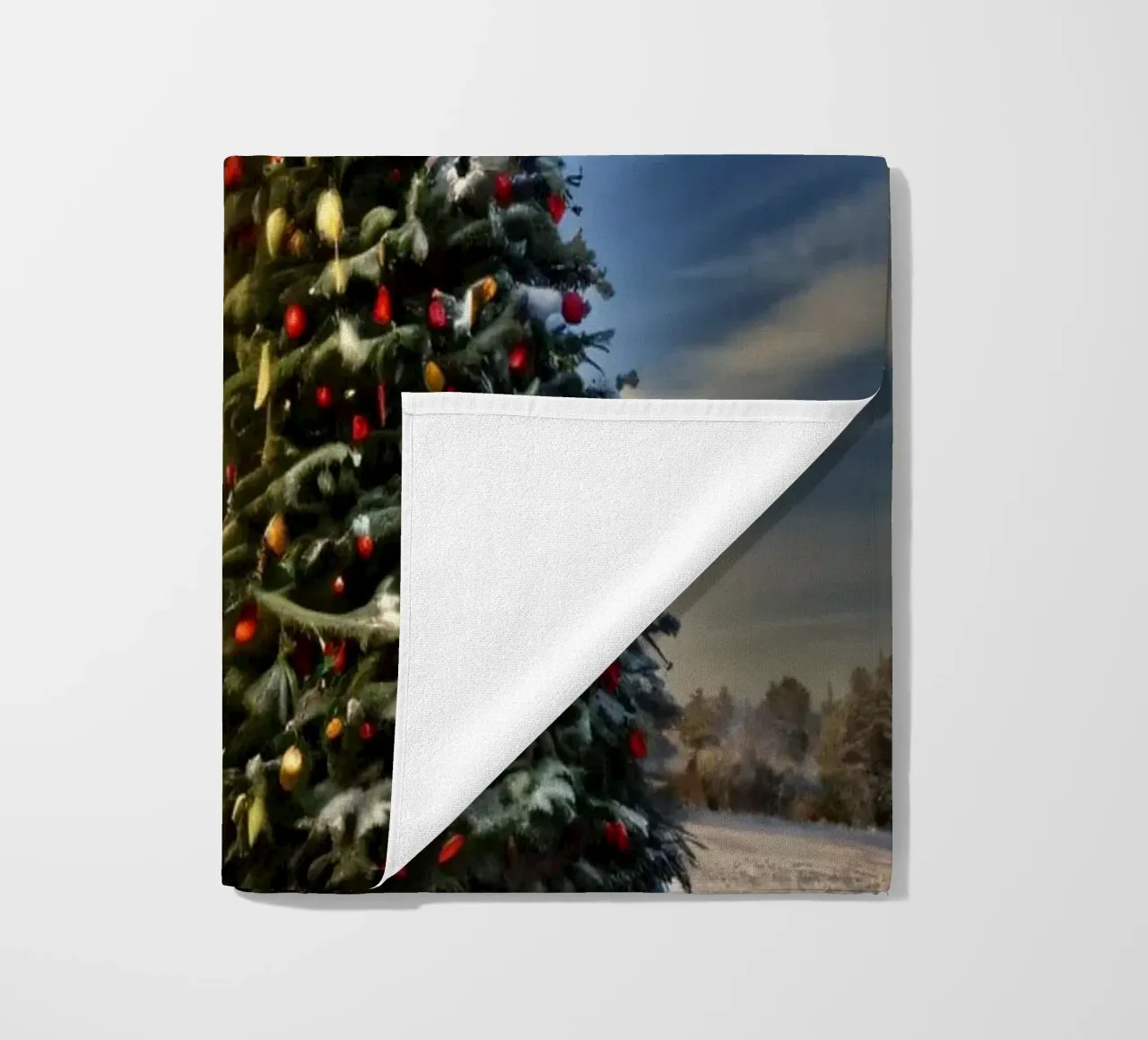 Snow-covered landscape featuring a decorated Christmas tree beach towel by DesignDoodle