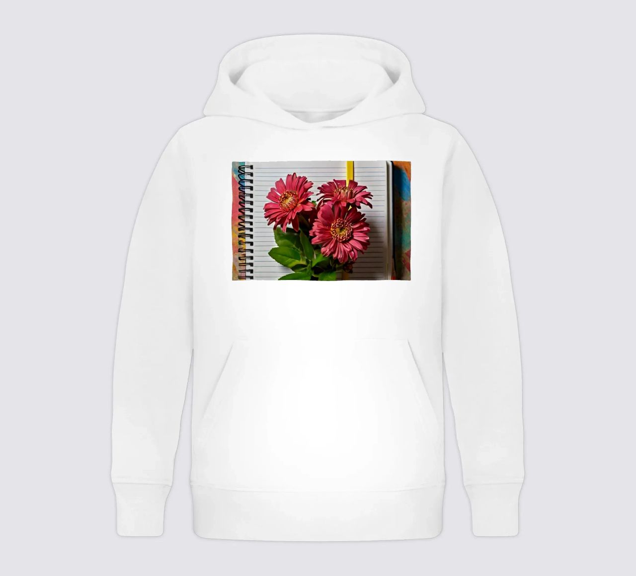 Un taccuino vivace con fiori rosa appoggiati in cima, che mette in mostra felpa bambino con cappuccio da DesignDoodle