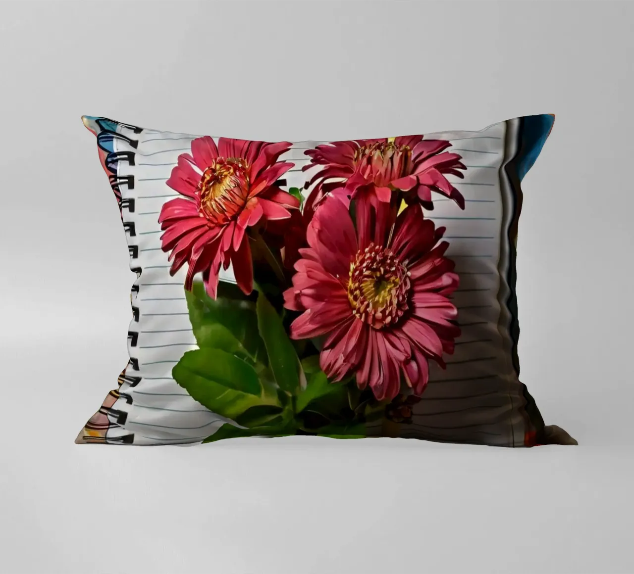 Een levendig notitieboek met roze bloemen erop, met daarop kussen van DesignDoodle