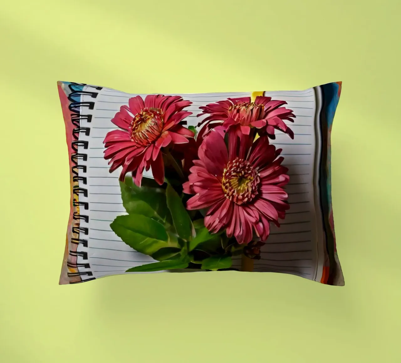 Een levendig notitieboek met roze bloemen erop, met daarop kussen van DesignDoodle