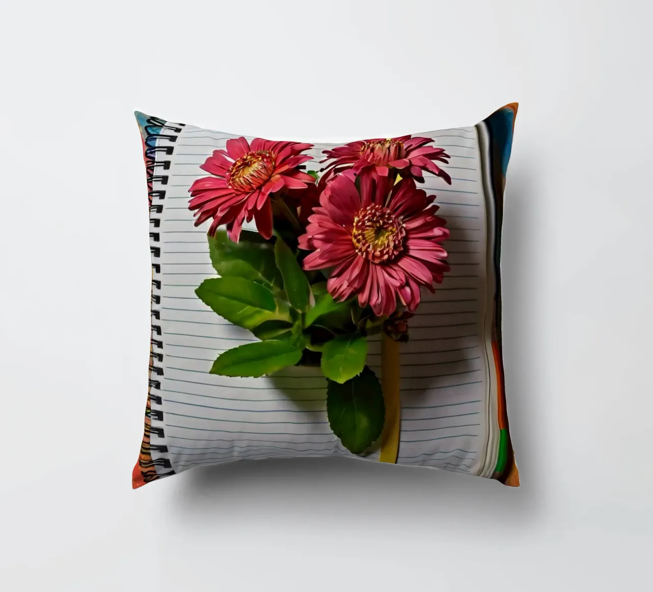 Un carnet de notes vibrant sur lequel reposent des fleurs roses. coussin de DesignDoodle