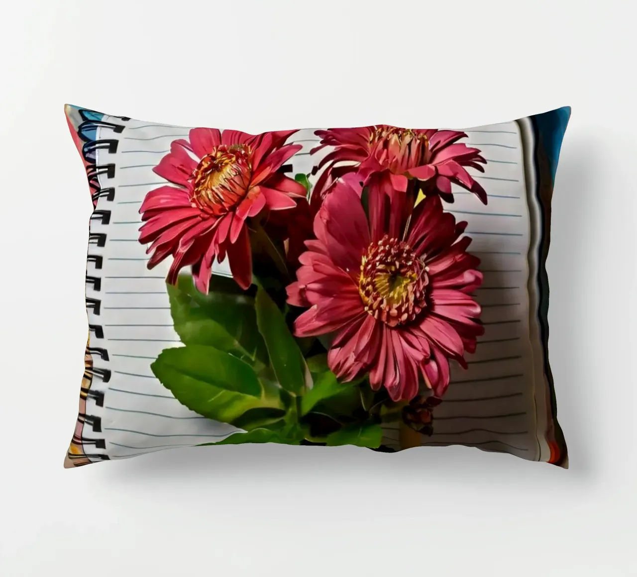 Een levendig notitieboek met roze bloemen erop, met daarop kussen van DesignDoodle