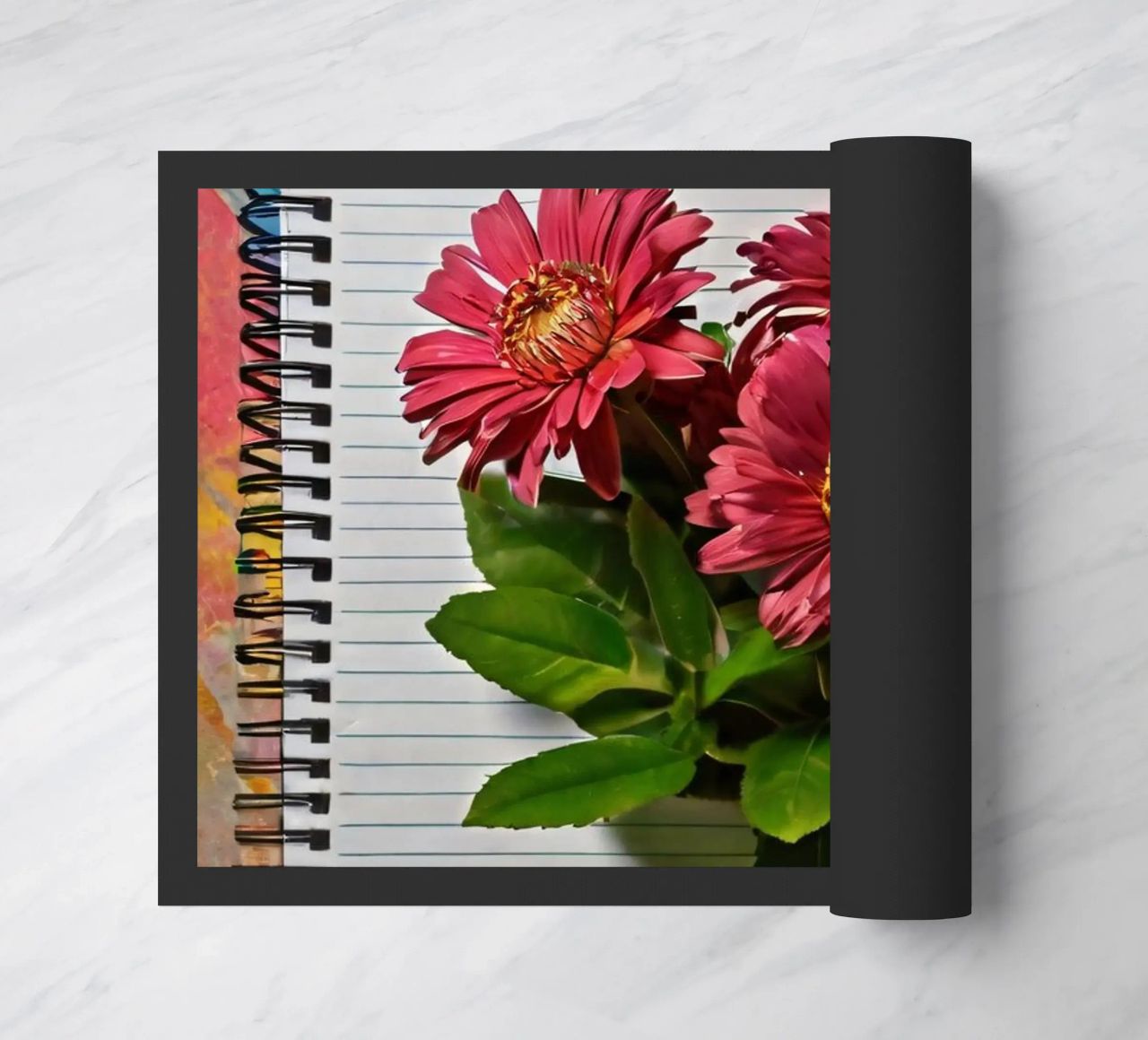 Un taccuino vivace con fiori rosa appoggiati in cima, che mette in mostra zerbino da DesignDoodle