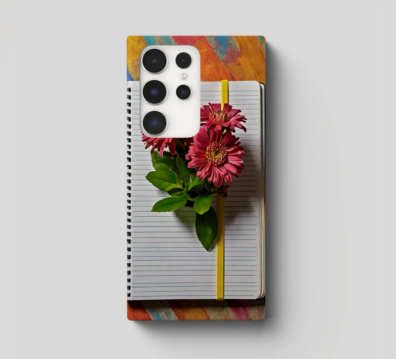 Un taccuino vivace con fiori rosa appoggiati in cima, che mette in mostra cover samsung da DesignDoodle