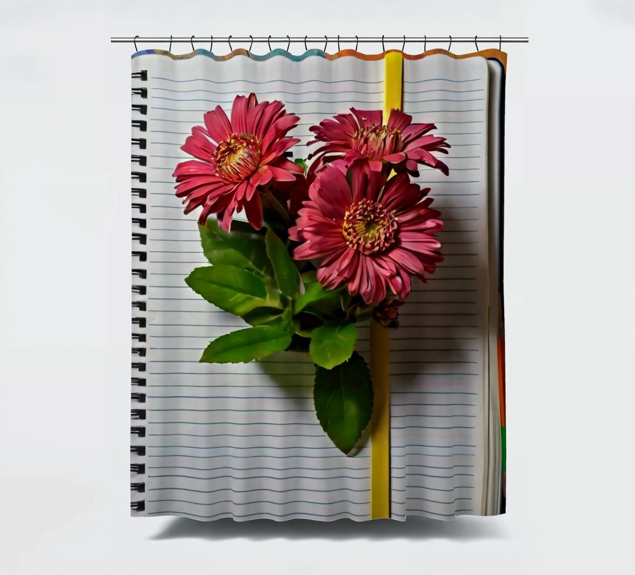Un taccuino vivace con fiori rosa appoggiati in cima, che mette in mostra tenda da doccia da DesignDoodle