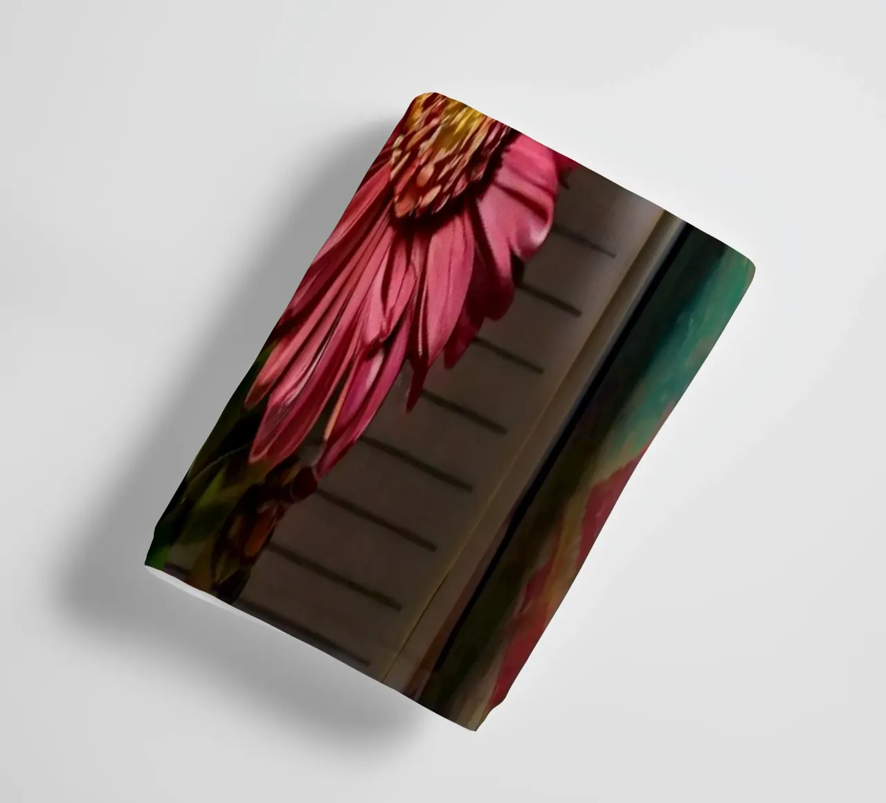 Un taccuino vivace con fiori rosa appoggiati in cima, che mette in mostra asciugamano da bagno da DesignDoodle