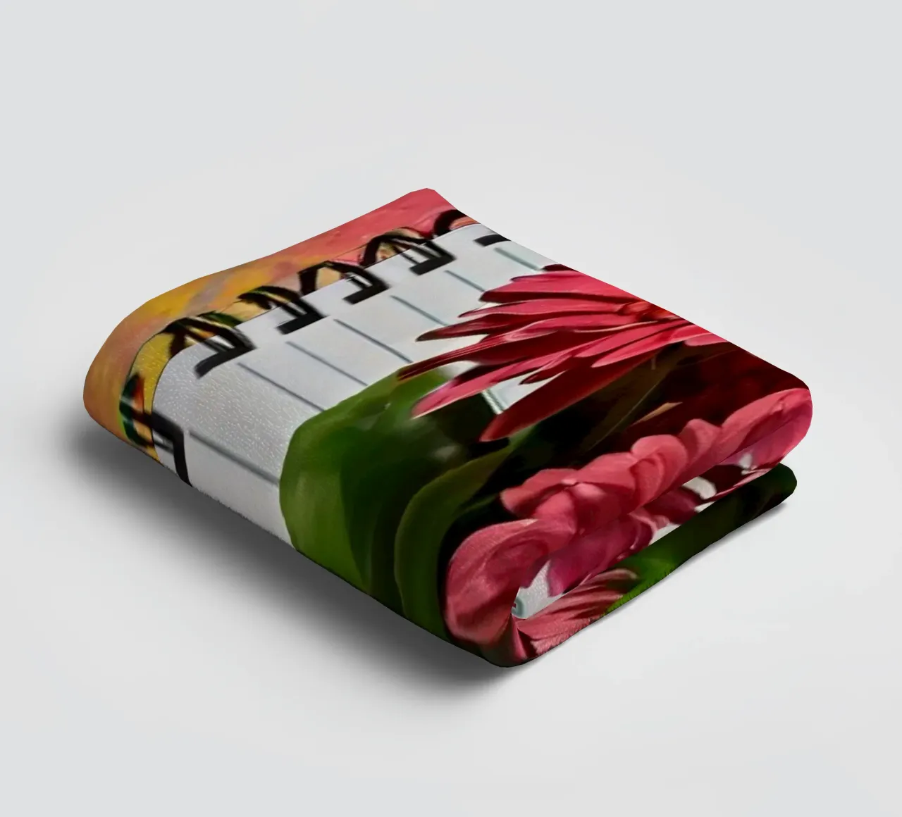 Un taccuino vivace con fiori rosa appoggiati in cima, che mette in mostra asciugamano da bagno da DesignDoodle