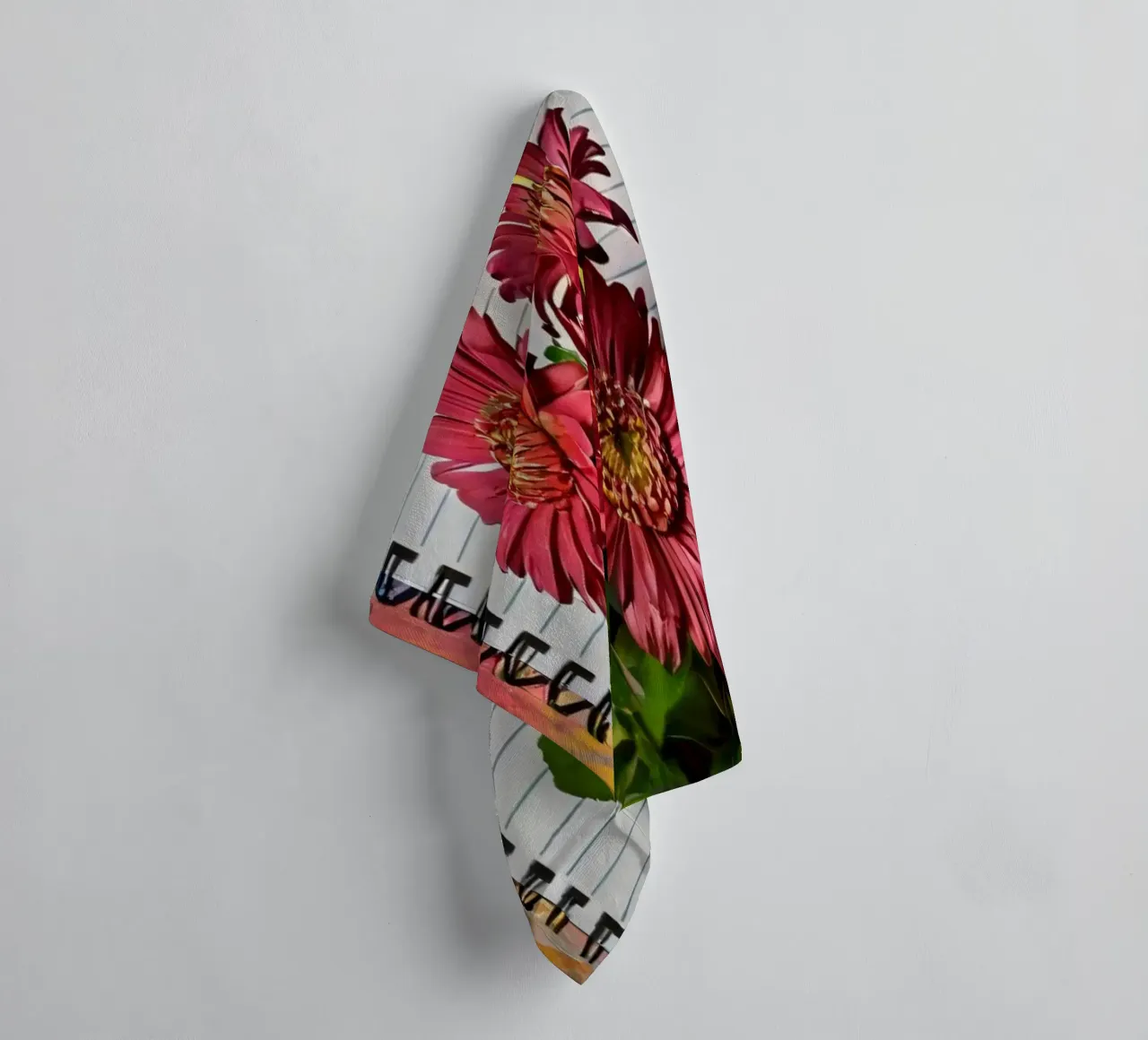 Un taccuino vivace con fiori rosa appoggiati in cima, che mette in mostra asciugamano da bagno da DesignDoodle