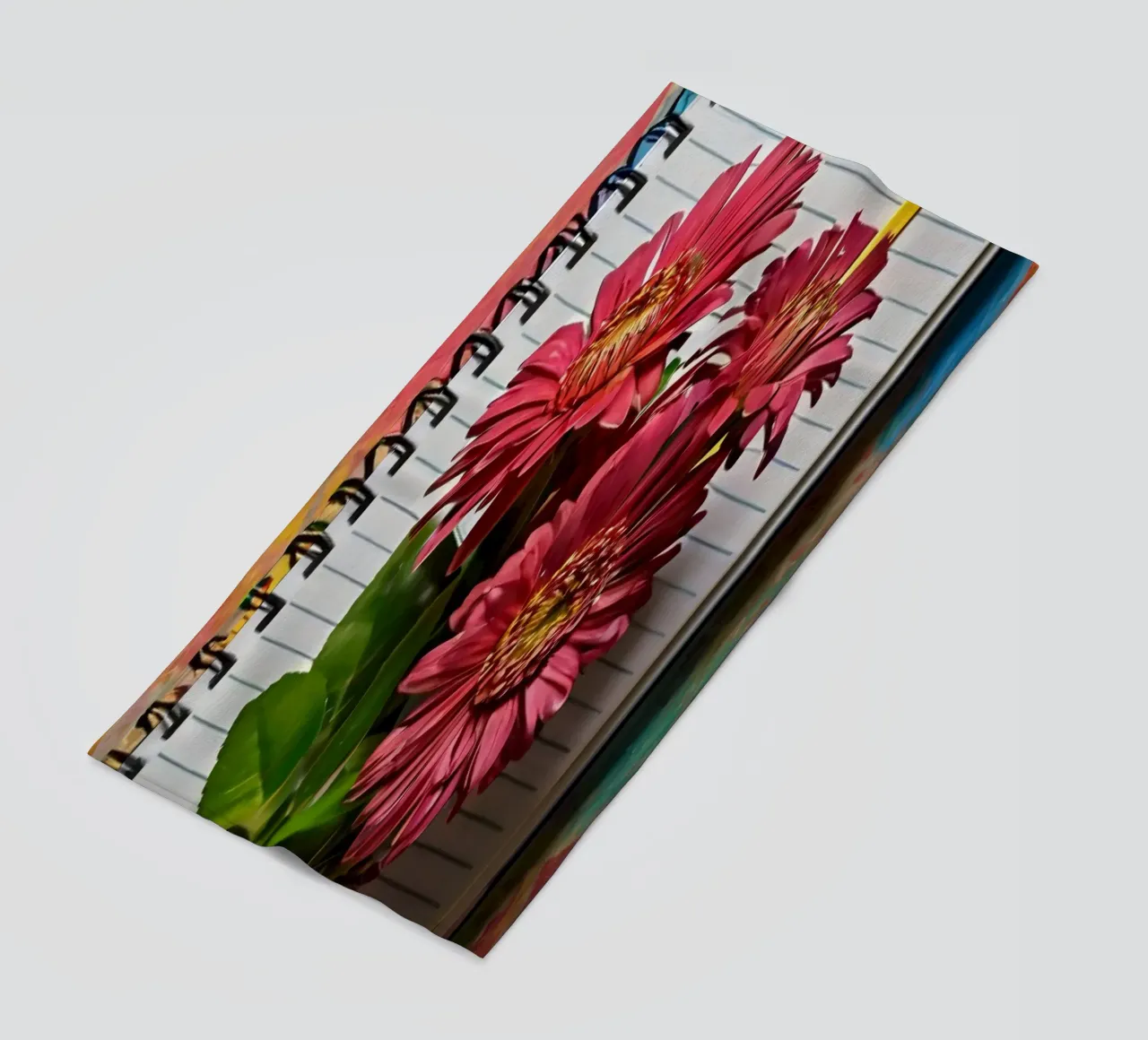 Ein leuchtendes Notizbuch mit rosafarbenen Blumen auf dem Kopf, die Strandtuch von DesignDoodle