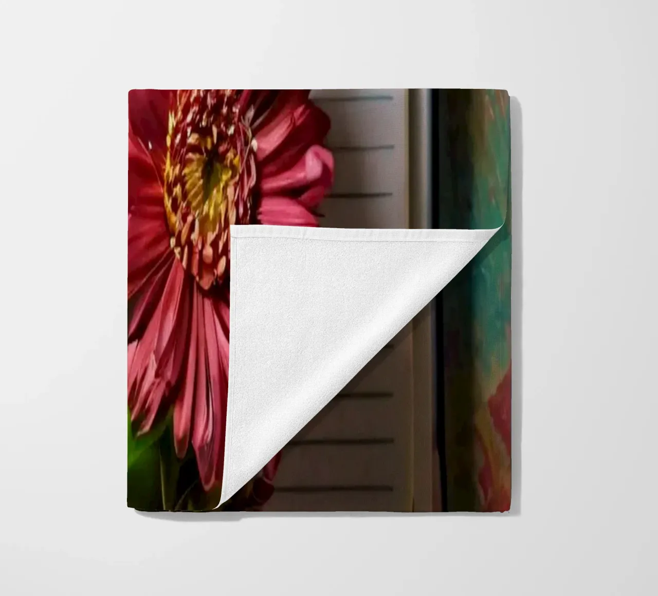 Un taccuino vivace con fiori rosa appoggiati in cima, che mette in mostra telo mare da DesignDoodle