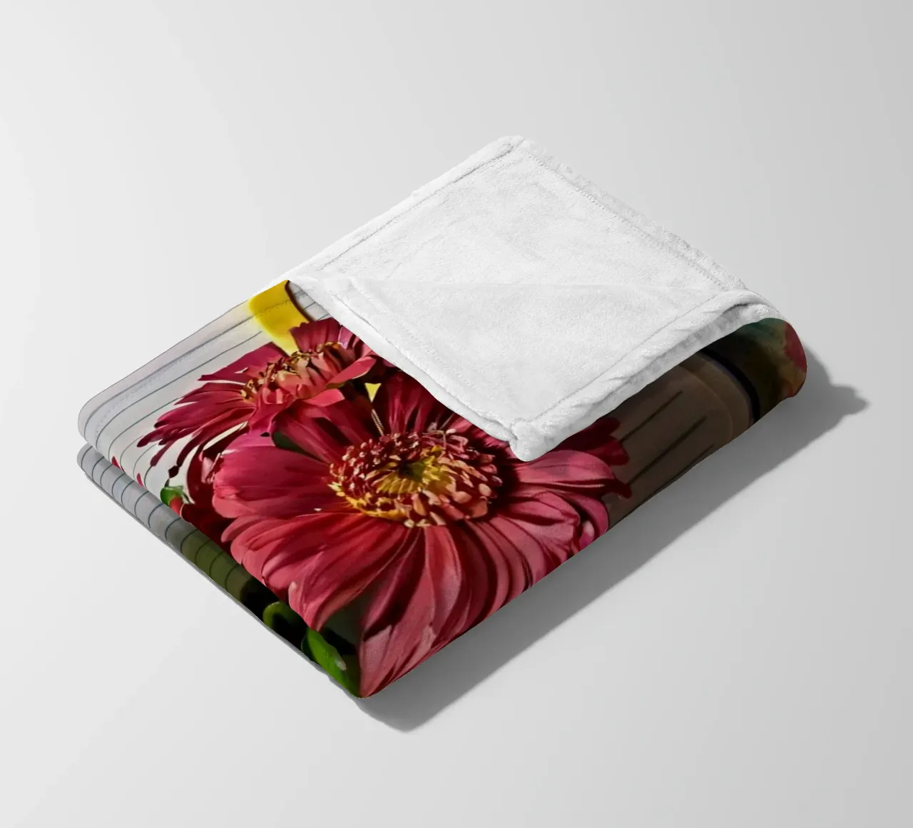 Un taccuino vivace con fiori rosa appoggiati in cima, che mette in mostra coperta in pile da DesignDoodle