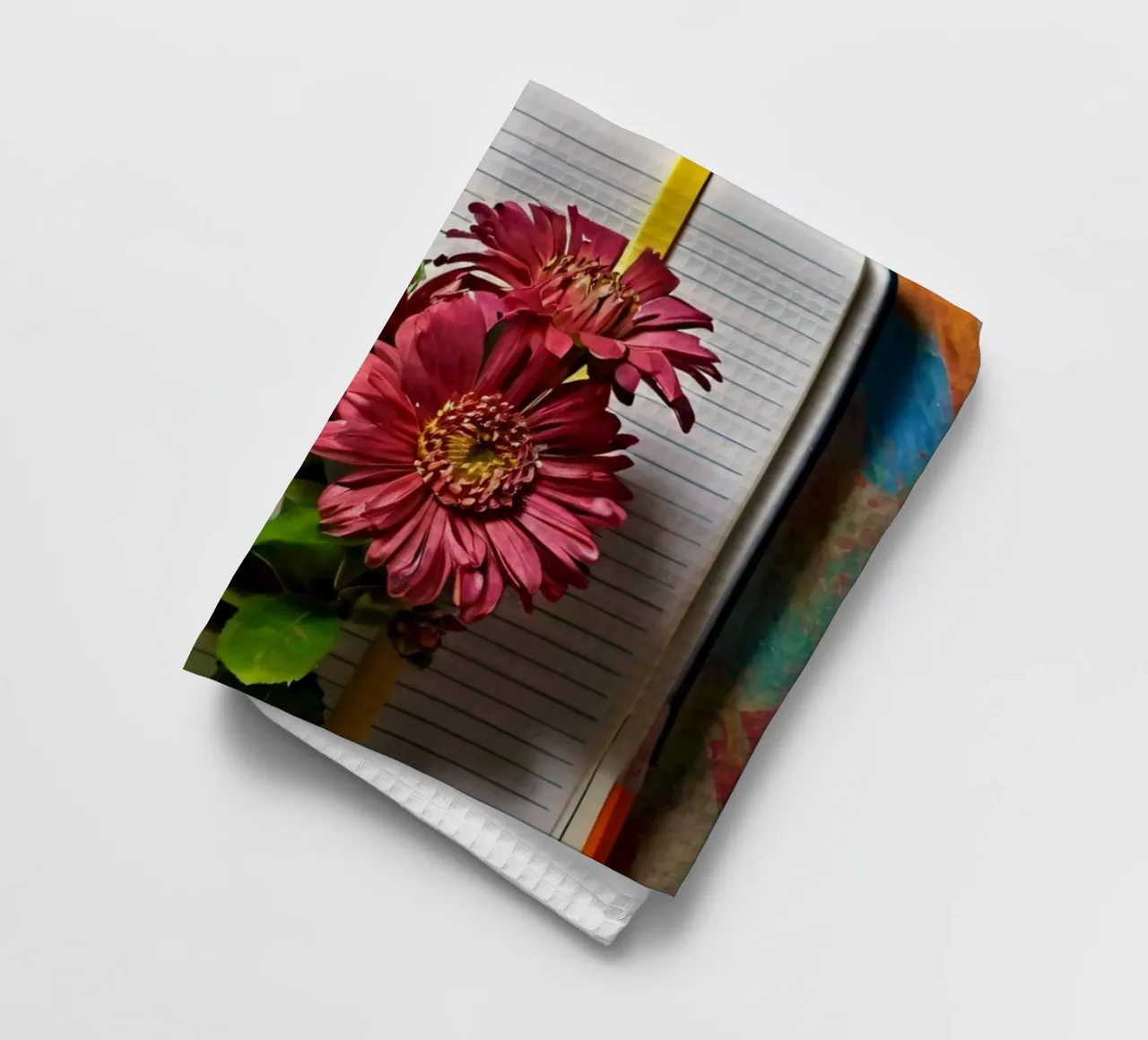 Ein leuchtendes Notizbuch mit rosafarbenen Blumen auf dem Kopf, die Geschirrtuch von DesignDoodle