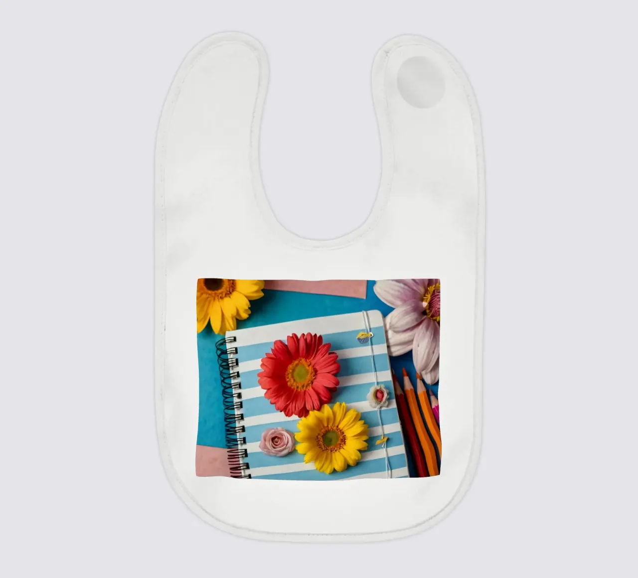 Taccuino colorato ornato di fiori e circondato da matite bavaglino da DesignDoodle