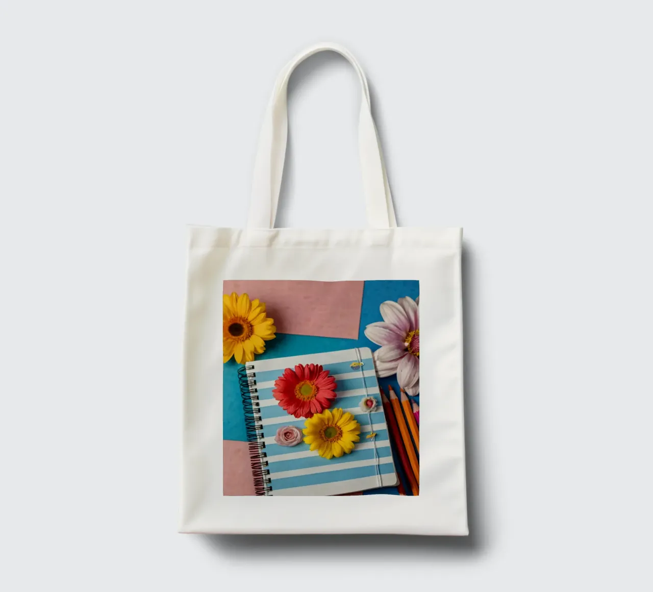 Colorful notebook adorned with flowers surrounded by pencils tote bag by DesignDoodle