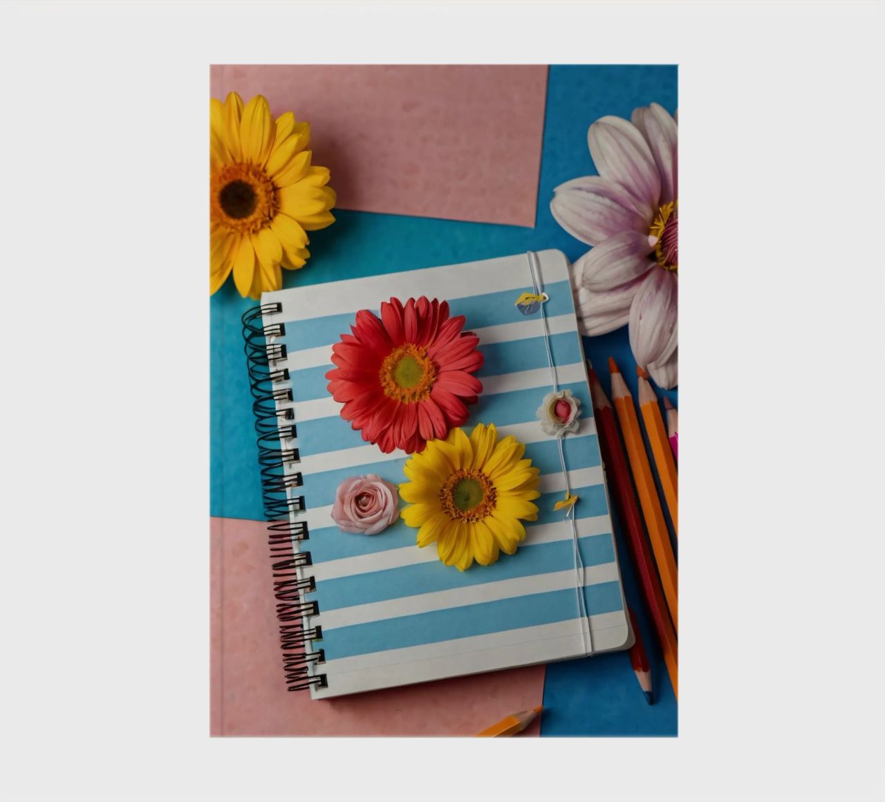 Colorful notebook adorned with flowers surrounded by pencils notebook by DesignDoodle
