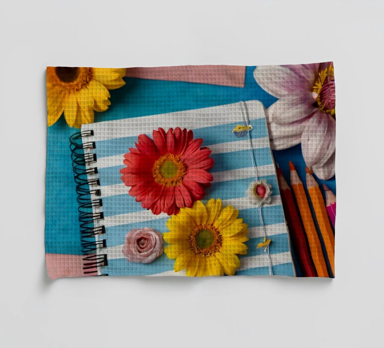 Colorful notebook adorned with flowers surrounded by pencils tea towel by DesignDoodle