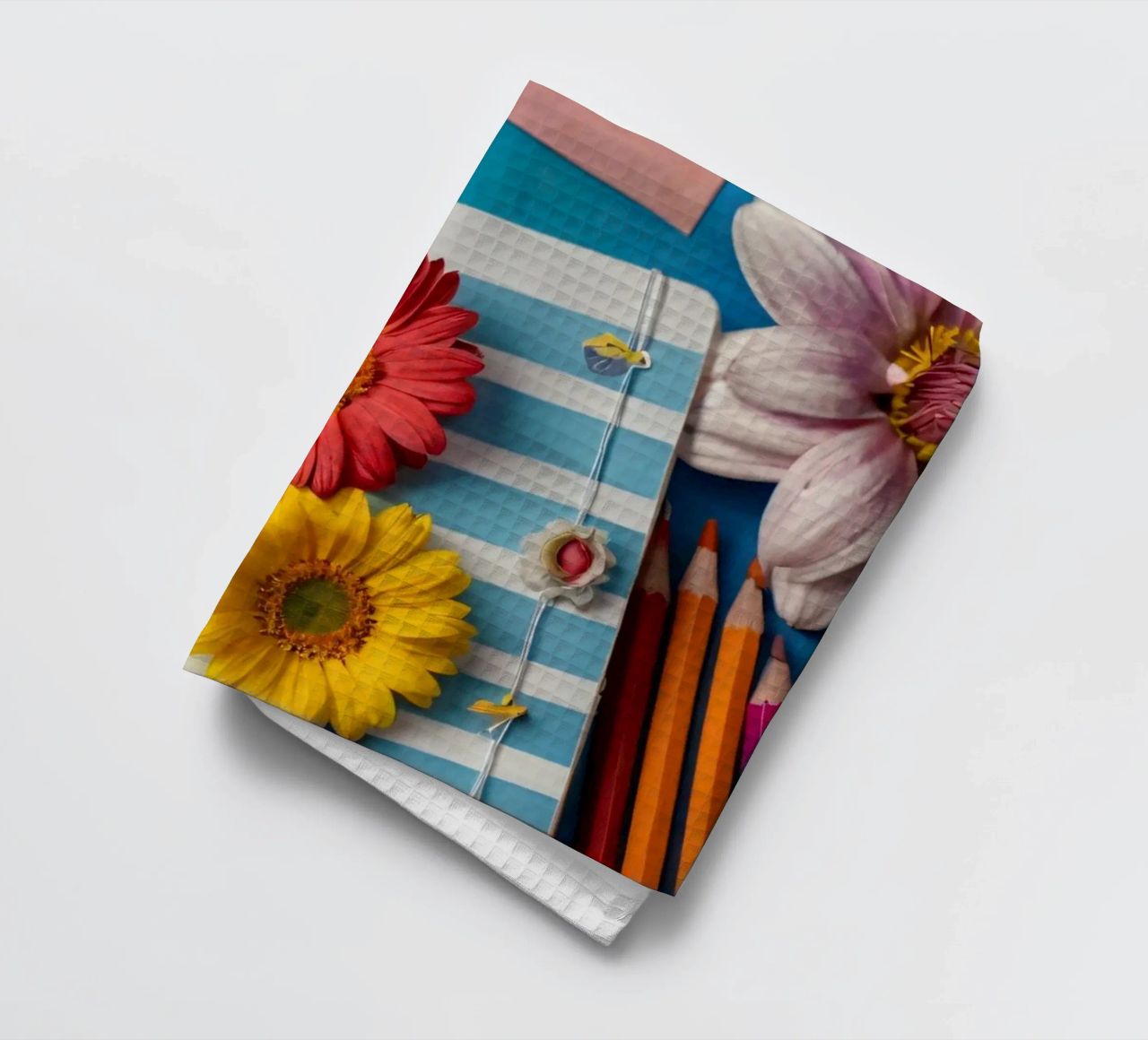 Colorful notebook adorned with flowers surrounded by pencils tea towel by DesignDoodle