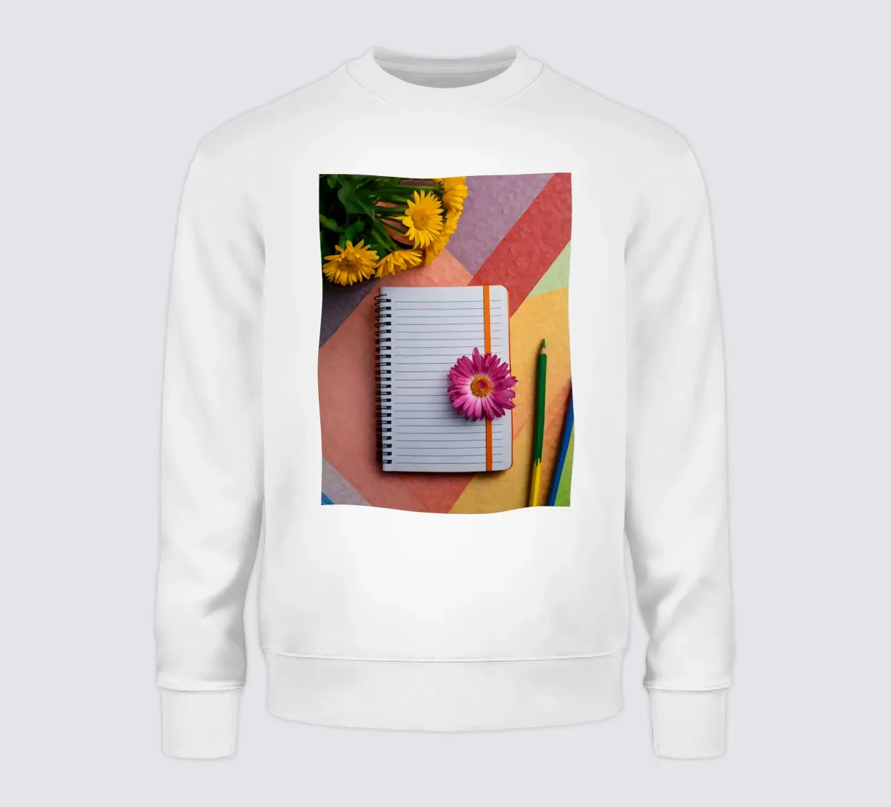 Kleurrijke werkplek met een notitieblok met een bloem sweatshirt van DesignDoodle