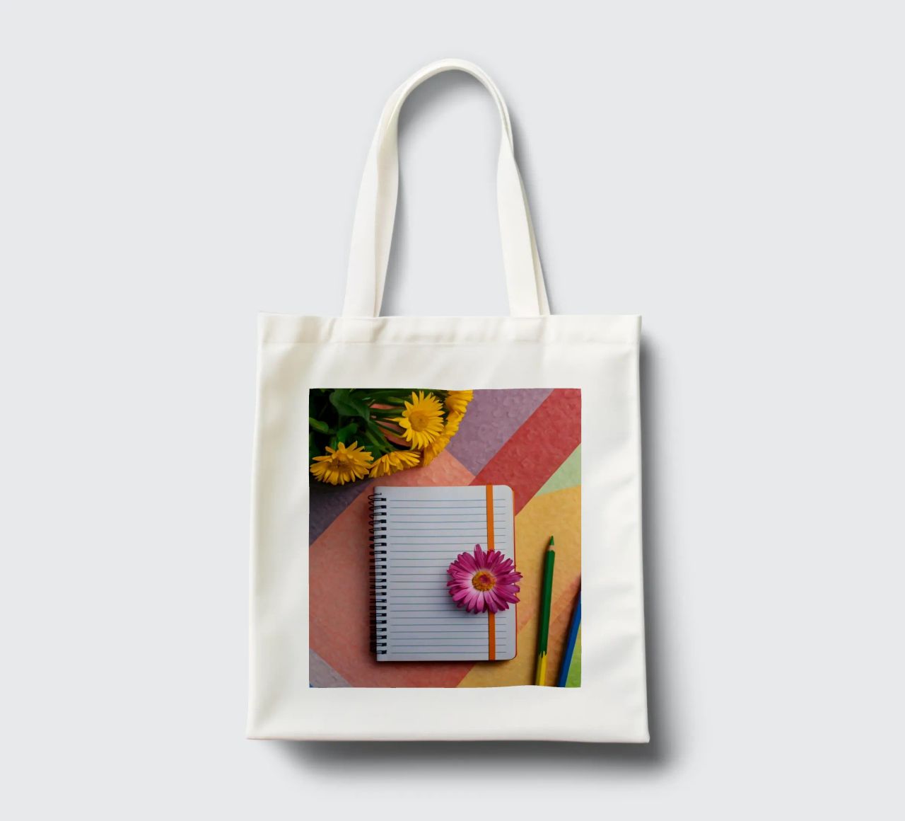 Uno spazio di lavoro colorato con un taccuino con un fiore borsa in juta da DesignDoodle