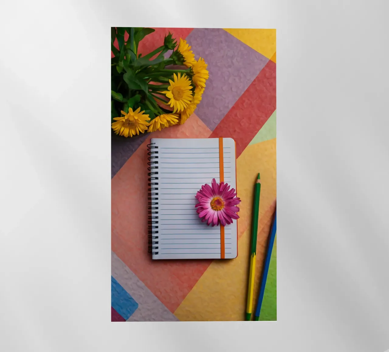 Uno spazio di lavoro colorato con un taccuino con un fiore pellicola backlit da DesignDoodle