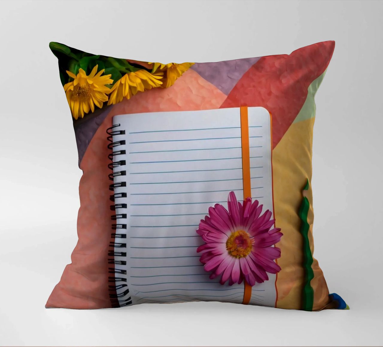 Uno spazio di lavoro colorato con un taccuino con un fiore cuscino da DesignDoodle